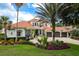 Elegant home exterior with lush landscaping, fountain, and three-car garage at 10342 Altrara Way, Trinity, FL 34655