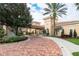 Elegant community center entryway with brick paved drive, lush landscaping, and beautiful architectural details at 10342 Altrara Way, Trinity, FL 34655