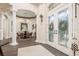 The foyer featuring tiled floors, a dining room with architectural columns, and decorative glass doors at 10342 Altrara Way, Trinity, FL 34655