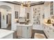 This kitchen boasts a cozy island with unique lighting, a stylish range hood, and attractive abstract art at 10342 Altrara Way, Trinity, FL 34655