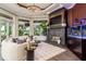 Inviting living room with a cozy sofa, fireplace, aquarium, and views of the outdoors at 10342 Altrara Way, Trinity, FL 34655