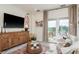 Comfortable living room with a TV, rustic wood cabinet and patio access at 10342 Altrara Way, Trinity, FL 34655