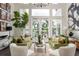 Sunlit living room with stylish furnishings and a view of the pool and outdoor area through large windows at 10342 Altrara Way, Trinity, FL 34655