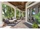 Inviting outdoor patio featuring wicker furniture, a coffered wood ceiling, and lush tropical landscaping at 10342 Altrara Way, Trinity, FL 34655