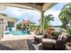 Relaxing patio area showcasing a pool, spa, outdoor kitchen, and lush landscaping, perfect for entertaining at 10342 Altrara Way, Trinity, FL 34655