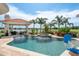 Beautiful in-ground pool and hot tub with a covered seating area with palm trees in the background at 10342 Altrara Way, Trinity, FL 34655