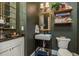 Charming powder room with an elegant sink, vanity, dark walls, decor, and a unique, stylish mirror at 10342 Altrara Way, Trinity, FL 34655