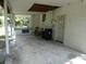 A covered back porch area with concrete flooring, exterior door, and space for outdoor seating at 1042 Howell Ave, Brooksville, FL 34601