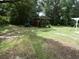 Large backyard with lush greenery, shed, and entertainment area at 1042 Howell Ave, Brooksville, FL 34601