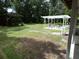 View of backyard featuring shed, pergola, and table set at 1042 Howell Ave, Brooksville, FL 34601