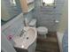 Cozy bathroom featuring a vanity sink, toilet, and shower with wood-look walls at 1042 Howell Ave, Brooksville, FL 34601