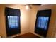 Cozy bedroom with hardwood floors, ceiling fan, and two windows with dark curtains at 1042 Howell Ave, Brooksville, FL 34601