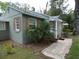 Charming exterior featuring a stone walkway, lush landscaping, and unique architectural details at 1042 Howell Ave, Brooksville, FL 34601