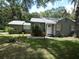 Charming single-story home featuring a well-maintained lawn and mature trees at 1042 Howell Ave, Brooksville, FL 34601