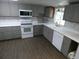 Well-equipped kitchen with white appliances, gray cabinets, and ample counter space at 1042 Howell Ave, Brooksville, FL 34601