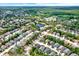 Expansive aerial view of a residential neighborhood with lush green trees, a small lake, and well-spaced single-Gathering homes at 10935 New Brighton Ct, New Port Richey, FL 34654