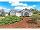 Well-maintained home featuring a two-car garage, manicured landscaping, and charming architectural details, including an arched window at 10935 New Brighton Ct, New Port Richey, FL 34654