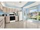 Cozy eat-in kitchen with white appliances and an oversized window with charming breakfast nook at 10935 New Brighton Ct, New Port Richey, FL 34654