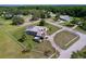 Aerial view of home with a long driveway, fenced yard, and mature trees at 10941 Hilltop Dr, New Port Richey, FL 34654