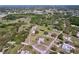 Aerial view showcasing property with fenced yards, mature shade trees, and nearby community at 10941 Hilltop Dr, New Port Richey, FL 34654