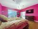 Bedroom showcasing hardwood floors, a ceiling fan, a dresser, and access to the bathroom at 10941 Hilltop Dr, New Port Richey, FL 34654