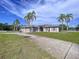Lovely house with a three-car garage, nice landscaping, and a concrete driveway and perimeter fence at 10941 Hilltop Dr, New Port Richey, FL 34654