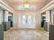 Grand foyer with a decorative front door, neutral tile flooring, and statement lighting and architectural columns at 10941 Hilltop Dr, New Port Richey, FL 34654