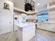 Bright kitchen featuring an island, modern appliances, ample cabinets, and a hanging pot rack at 10941 Hilltop Dr, New Port Richey, FL 34654