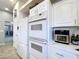 Well-lit kitchen featuring modern appliances, including double ovens and a large refrigerator at 10941 Hilltop Dr, New Port Richey, FL 34654