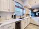 Bright kitchen boasting stainless steel appliances and white countertops, complemented by ample natural light at 10941 Hilltop Dr, New Port Richey, FL 34654