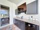 Outdoor kitchen complete with granite countertops, sink and beverage cooler and tv at 10941 Hilltop Dr, New Port Richey, FL 34654