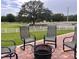 Brick patio area with outdoor seating, firepit, and expansive pasture view with horses and a white fence at 10941 Hilltop Dr, New Port Richey, FL 34654