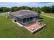 Aerial view of a large backyard with a brick patio, screened pool, and white fencing around the property at 10941 Hilltop Dr, New Port Richey, FL 34654