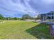 Sprawling green yard with white fencing and trees, and a brick patio with outdoor seating and a screened pool at 10941 Hilltop Dr, New Port Richey, FL 34654