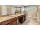 Bathroom featuring a double vanity with stone countertops and dark wood cabinetry at 1104 Ketzal Dr, Trinity, FL 34655