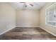 Empty bedroom features wood-look floors, a ceiling fan, and a window for natural light at 1104 Ketzal Dr, Trinity, FL 34655