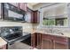 Close-up of kitchen featuring granite countertops, stainless steel appliances, and dark wood cabinets at 1104 Ketzal Dr, Trinity, FL 34655