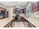 Kitchen features granite countertops, dark wood cabinets, and stainless steel appliances at 1104 Ketzal Dr, Trinity, FL 34655