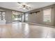 Open living room with tile floors, ceiling fan, and sliding glass doors to the screened patio at 1104 Ketzal Dr, Trinity, FL 34655