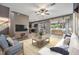 Open concept living room features tile floors, a ceiling fan, and access to the screened-in patio at 1104 Ketzal Dr, Trinity, FL 34655