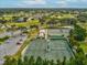 Aerial view of tennis courts and golf course highlighting a well-maintained landscape and recreational facilities at 11144 Brambleleaf Way, Hudson, FL 34667