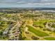 Aerial view featuring a golf course, homes, and picturesque scenery within a vibrant community setting at 11144 Brambleleaf Way, Hudson, FL 34667