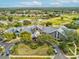 Aerial view of clubhouse with golf course, pool, and parking area at 11144 Brambleleaf Way, Hudson, FL 34667