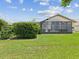 Spacious backyard with green grass and a screened-in lanai; offering privacy and outdoor living at 11144 Brambleleaf Way, Hudson, FL 34667