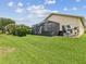 Expansive backyard with lush green grass and an enclosed lanai, perfect for outdoor living at 11144 Brambleleaf Way, Hudson, FL 34667