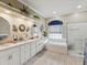 Bright bathroom with dual sinks, soaking tub, and glass enclosed shower at 11144 Brambleleaf Way, Hudson, FL 34667