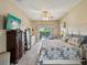 Comfortable bedroom with pool view features a ceiling fan, TV, and stylish decor at 11144 Brambleleaf Way, Hudson, FL 34667