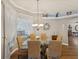 A dining room with wicker chairs, a chandelier, and a view of the living room at 11144 Brambleleaf Way, Hudson, FL 34667