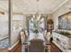 Elegant dining room featuring a large window, chandelier lighting, and stylish decor at 11144 Brambleleaf Way, Hudson, FL 34667