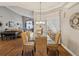 A dining room with wicker chairs, a chandelier, and a view of the living room at 11144 Brambleleaf Way, Hudson, FL 34667